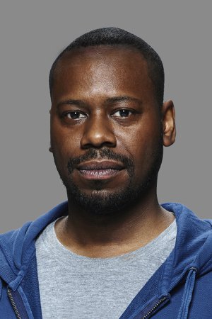 A headshot of a man in a blue hoodie.