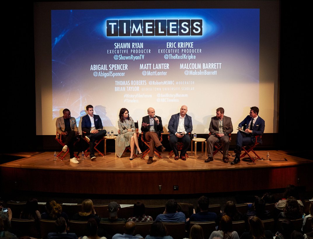 A panel of speakers from the cast of “Timeless” seated on a small stage in front of an audience.